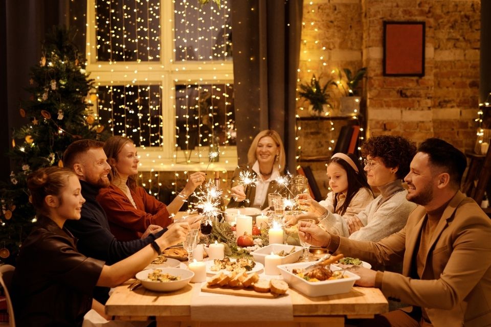 Family gathering around dinner table with sparklers